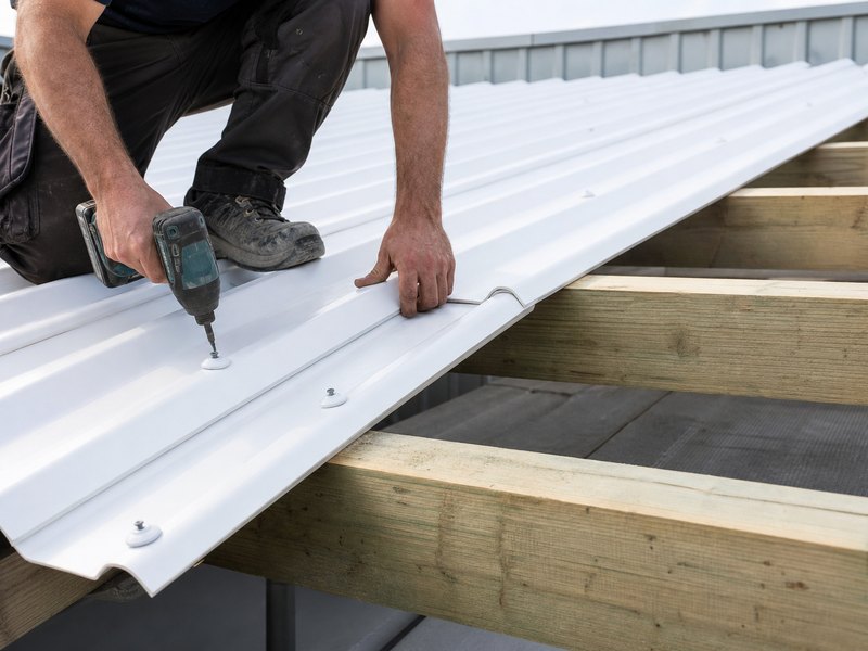 Roofer fastening white corrugated PVC roofing sheets with sealing washers
