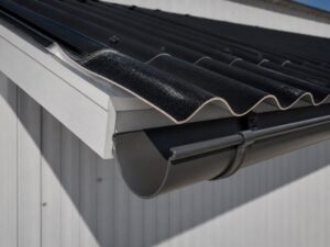 Black curved-profile roofing sheet projecting past a fascia into an eave gutter